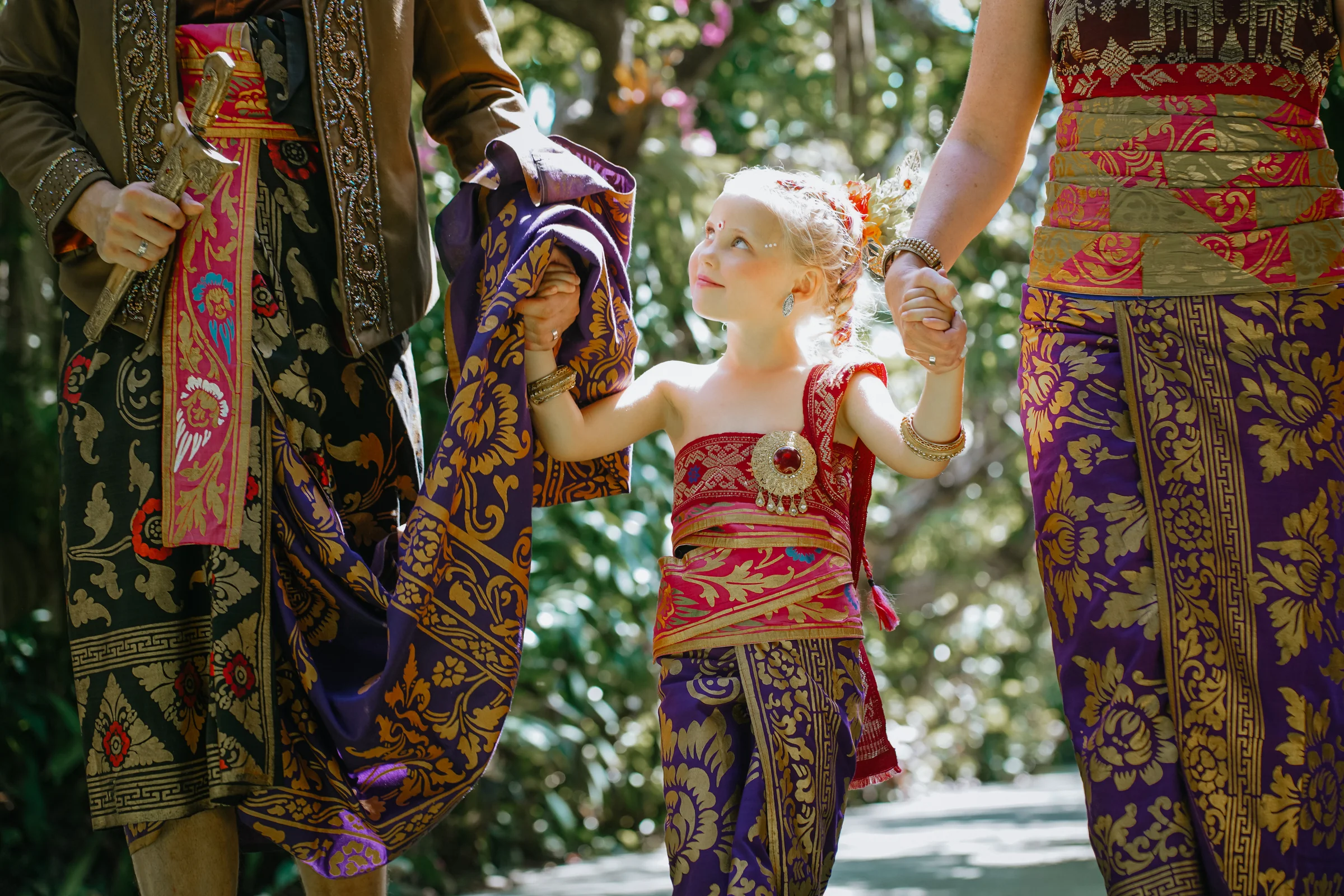 A family portrait in Balinese ceremonial attire within the Mahagiri garden